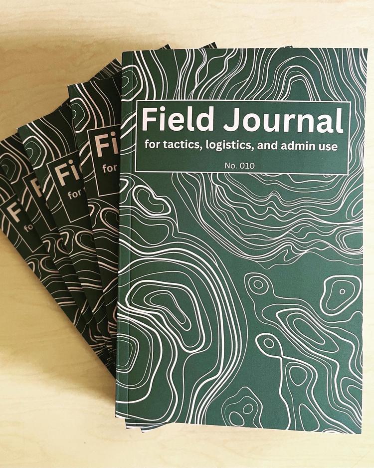 Field Journals fanned out on tabletop.